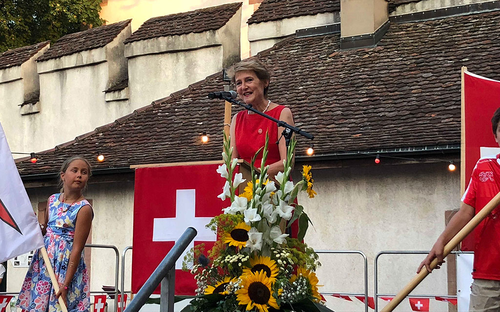 Bundesrätin Simonetta Sommaruga steht am blumengeschmückten Rednerpult.