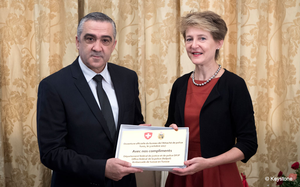 La conseillère fédérale Simonetta Sommaruga (à droite) et le ministre tunisien de l’Intérieur Lofti Brahem (à gauche) présentent une plaquette en laiton réalisée à l’occasion de l’ouverture du bureau de coopération policière