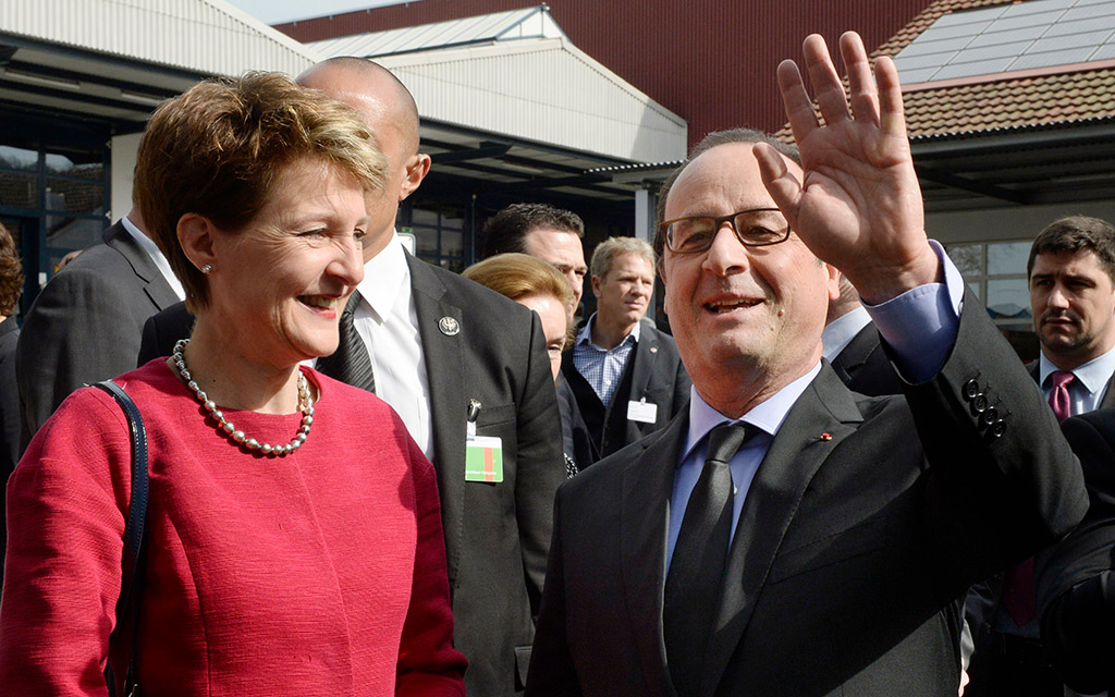 Bundespräsidentin Simonetta Sommaruga und Präsident François Hollande begrüssen die Zuschauer bei ihrem Besuch der Cleantech-Firma Ernst Schweizer AG in Hedingen ZH (Foto: Keystone)